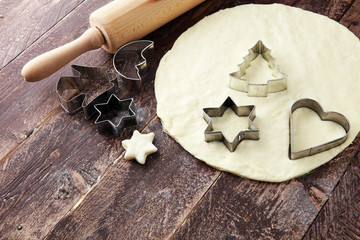 Christmas baking ingredients and tolls for dough preparation. Flour, rolling pin and cookie cutters.