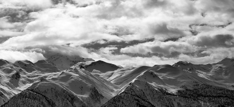 Fototapeta Black and white panoramic view on snowy mountains and cloudy sky in evening