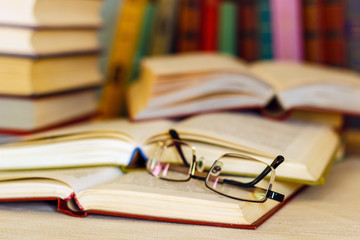 on the table are many books and glasses.