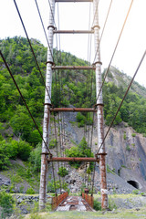 Road Suspension bridge over a mountain river during a rain in Georgia