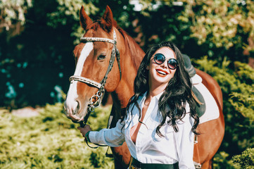 Obraz premium fashionable brunette with a racehorse
