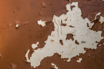 Concrete wall with cracking peeling brown paint 