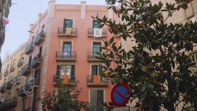 View of waving catalonian flags hanging on balconies of red building