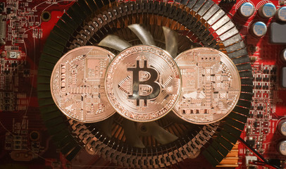 silver coins bitcoin are on the heatsink of the video card in the red light