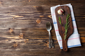 Food cooking background with wooden cutting board, cutlery and spices. Top view with copy space.