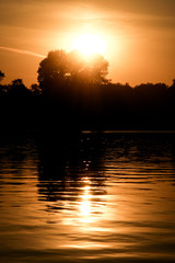 Silhouette of sunset on a river with reflection of the sun