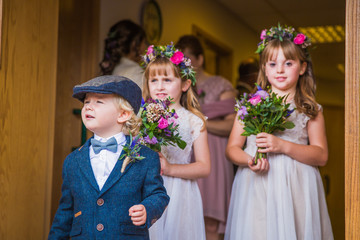 The little cheerful beautiful children standing with flowers and waiting wedding