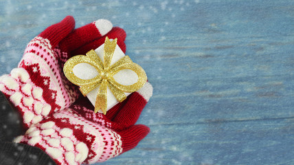 gift box packing of gold color in hands of a girl