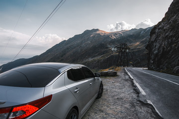 Naklejka premium Car on a beautiful mountains road, sport car on a highway, amazing sky with clouds, peak 