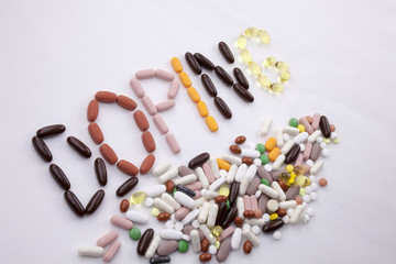 Conceptual Hand writing text caption inspiration Medical care Health concept written with pills drugs capsule word doping On white isolated background with copy space