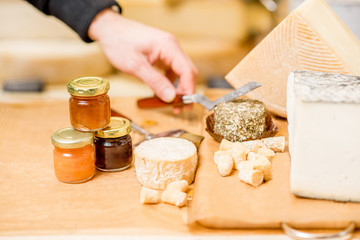 Cheese assortment with sweet jams on the table in the cheese shop
