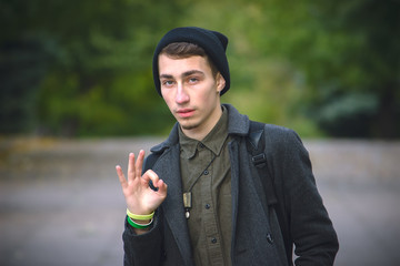 Happy young man gesturing OK sign against green background