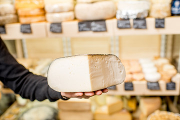 Holding a piece of seasoned cheese on the cheese showcase background