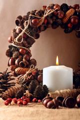 Advent wreath of acorn , cones and therds with burning candles for the pre Christmas time.Warm photo