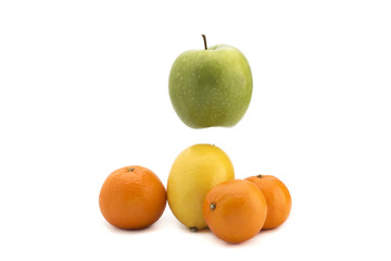 Orange tangerines, yellow lemon, green apple on a white background