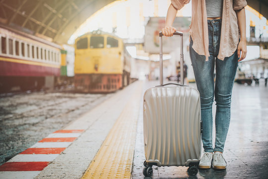 Woman traveler tourist standing with luggage at train station. Active and travel lifestyle concept