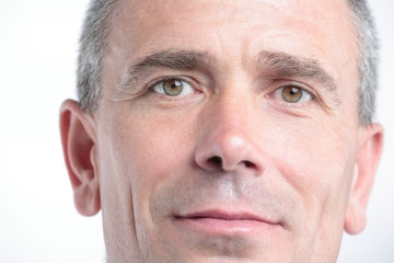 Portrait of successful mature business man smiling against white