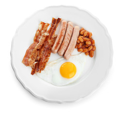 Plate with fried egg, sausages, bacon and beans on white background