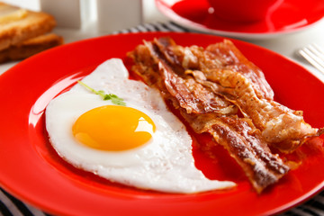 Plate with fried egg and bacon, closeup