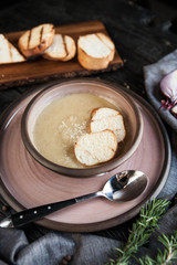 Beautifully served onion soup with croutons on a wooden dark table