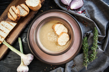 Beautifully served onion soup with croutons on a wooden dark table