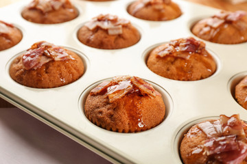 Tasty bacon muffins in mold on table