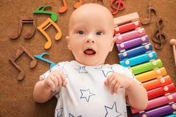 Cute boy with xylophone on color textile