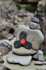 A wooden spinner lies on strange stone structures in the forest