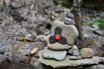 A wooden spinner lies on strange stone structures in the forest