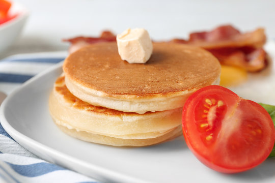 Tasty breakfast with pancakes and tomato on plate