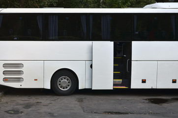 White tourist bus for excursions. The bus is parked in a parking lot near the park