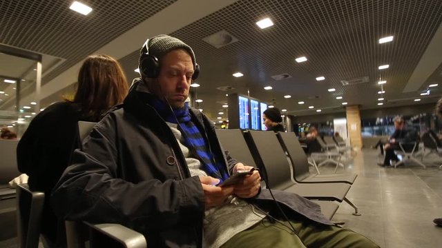 Man with the phone in the departure lounge waiting for the flight