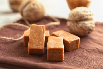 Delicious caramel candies on table