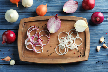 Composition with different onions on wooden table