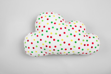 Soft pillow in shape of cloud on light background