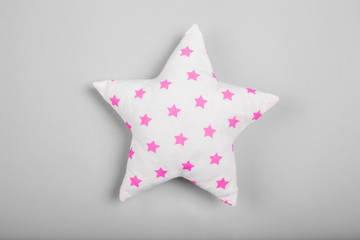 Soft pillow in shape of star on light background
