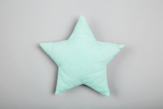Soft pillow in shape of star on light background