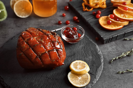 Slate plate with traditional honey baked ham and cranberry sauce on table