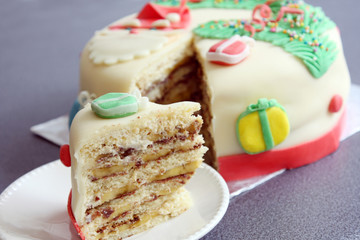 slice, portion of handmade decorated with sugar paste, fondant christmas cake: cut of banana and chocolate cake