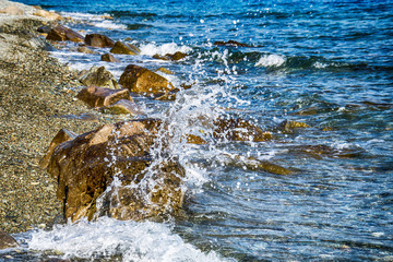 Fototapeta premium Scenic water splash and a rock in ocean