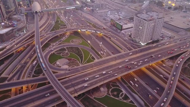 Aerial top view of highway junction with traffic in Dubai, UAE, at sunset. Famous Sheikh Zayed road in Dubai downtown. Transportation and driving concept view from rooftop