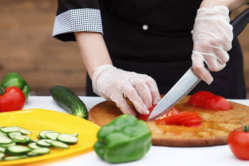 The cook cuts fresh farm vegetables