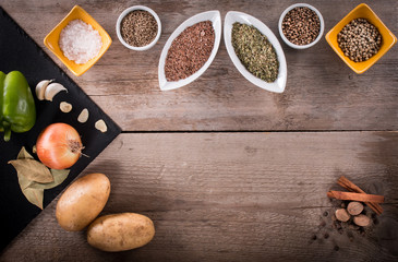 Fresh vegetables, Spices and herbs scattered on dark background. Natural and bio ingredients for cooking. Organic products on slate tray. Top view and copy space for your text.