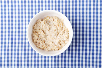 Healthy vegetarian cereal breakfast. Oats in white bowl.