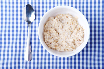 Healthy vegetarian cereal breakfast. Oats in white bowl.