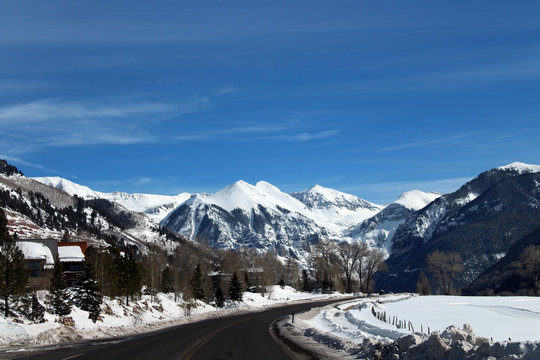 Snowy road travel with a view of the snow capped mountains ahead
