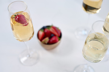 Glasses on champagne with strawberries on table