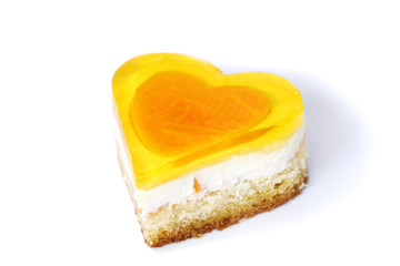 isolated on white background decorated heart shape multilayer papaya and peach cake with fruit jelly, cream and pieces of fresh fruits, with love for sweet heart
