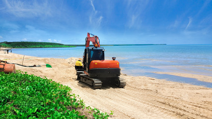 digger moving beach sand after erosion