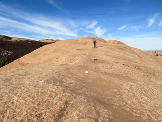 Mountain biker climbing a sandstone hill at Slickrock mountain biking trail in Moab, Utah